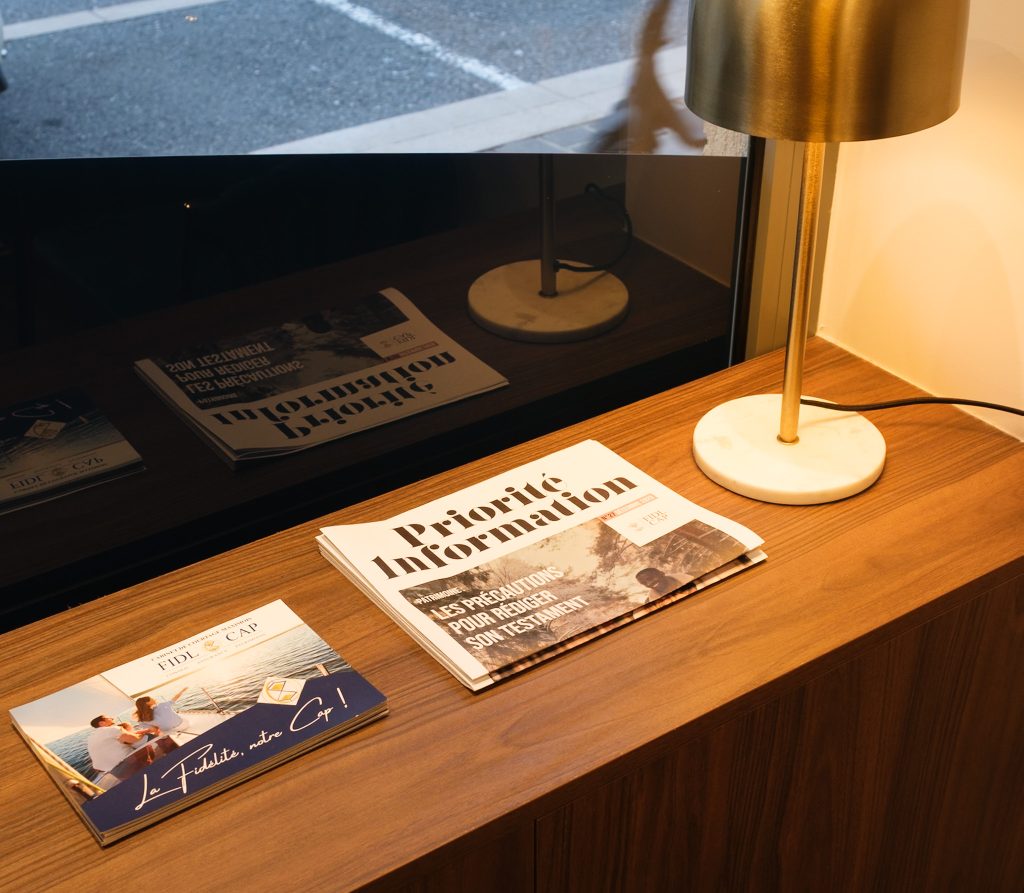 Journal d’information et plaquette FIDL CAP sur un bureau de l’agence